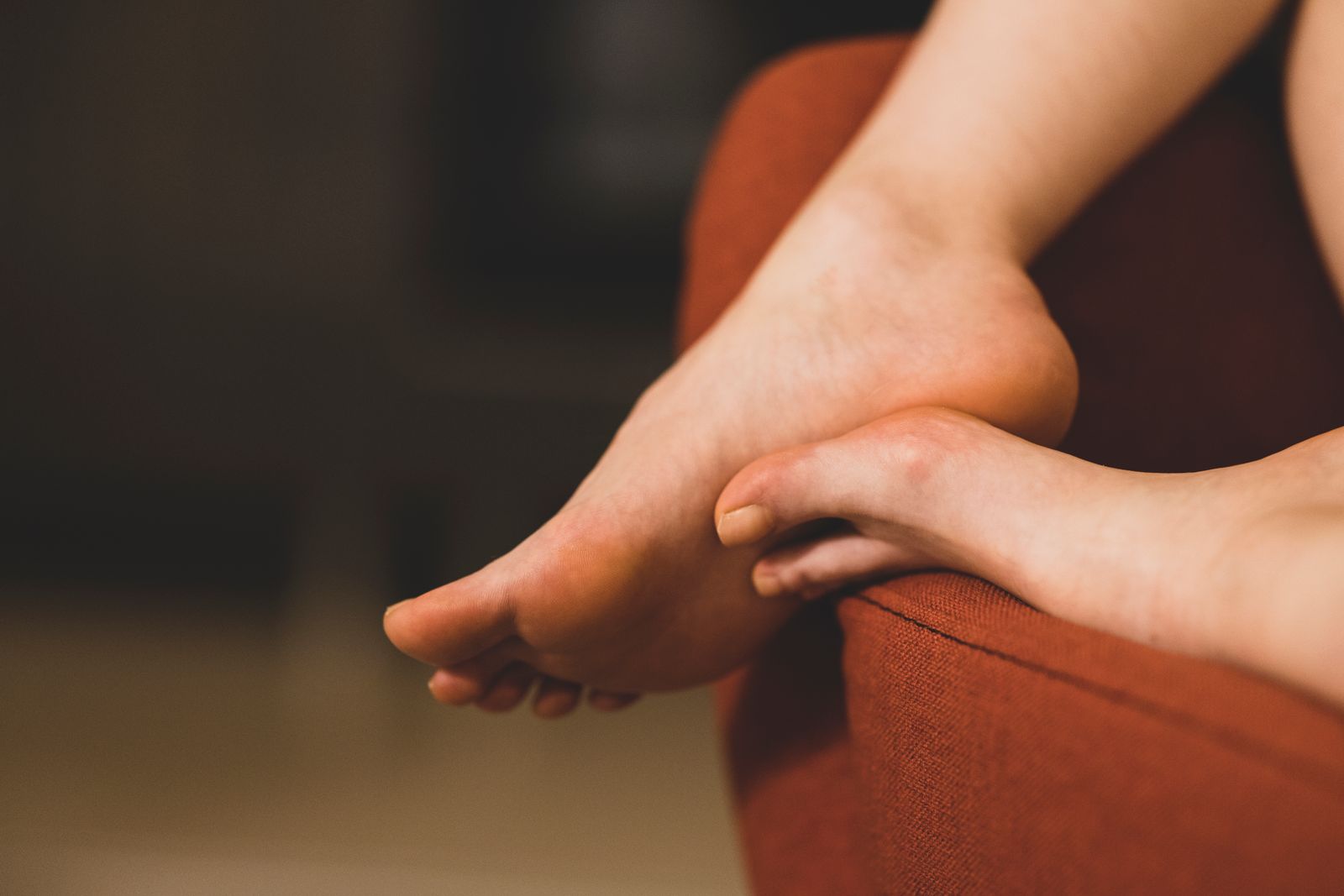 A person's feet resting on a sofa, relaxing at home.