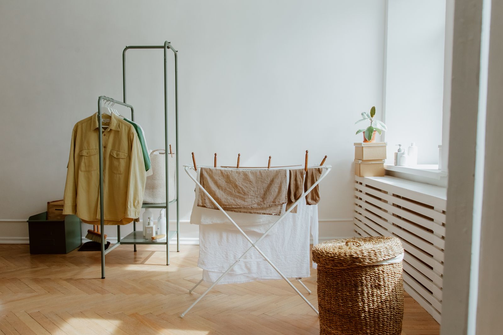 Washing hung to dry indoors on a rack in a bright room.